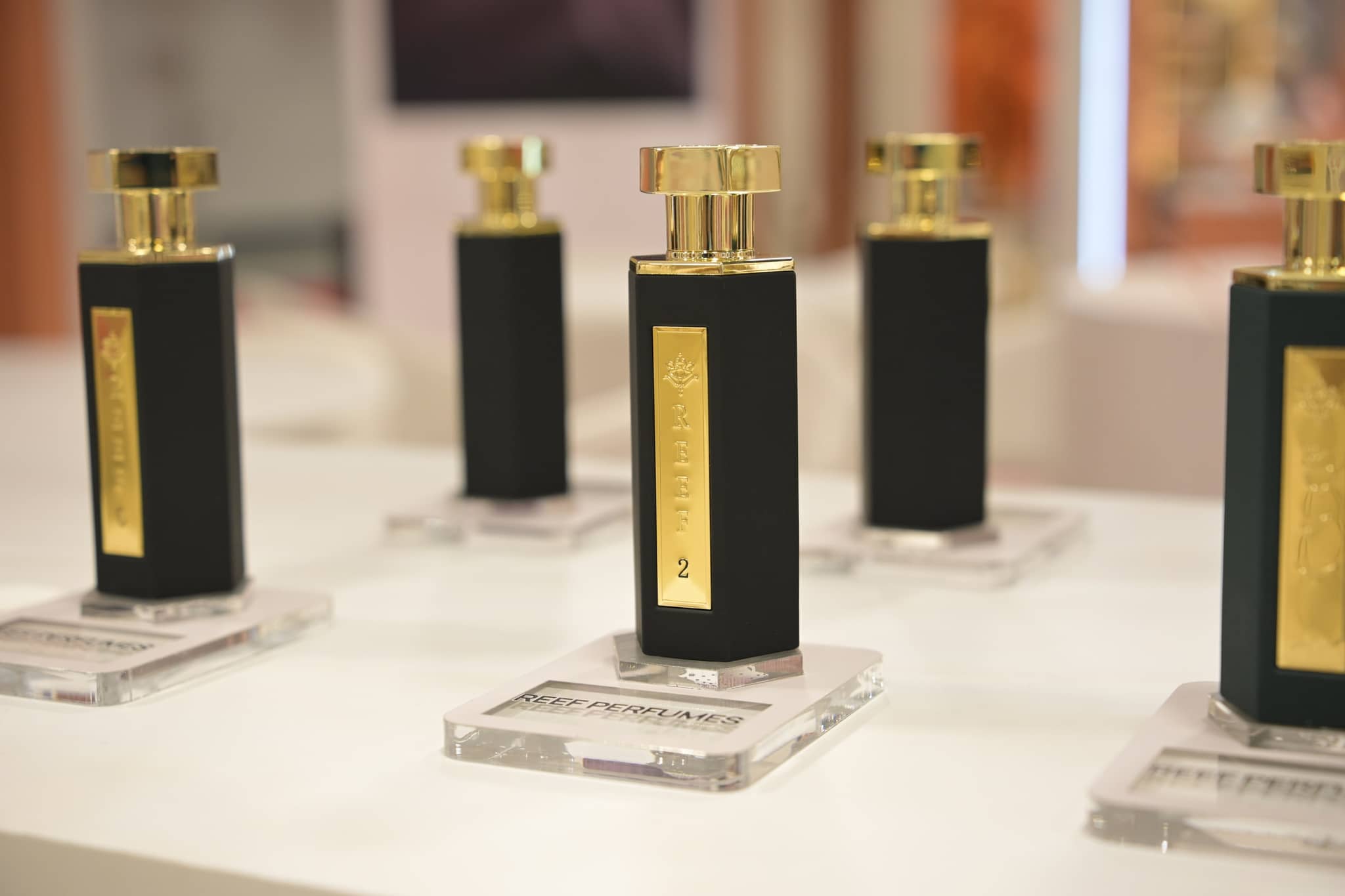 Black and gold fragrance bottles arranged on the REEF display counter